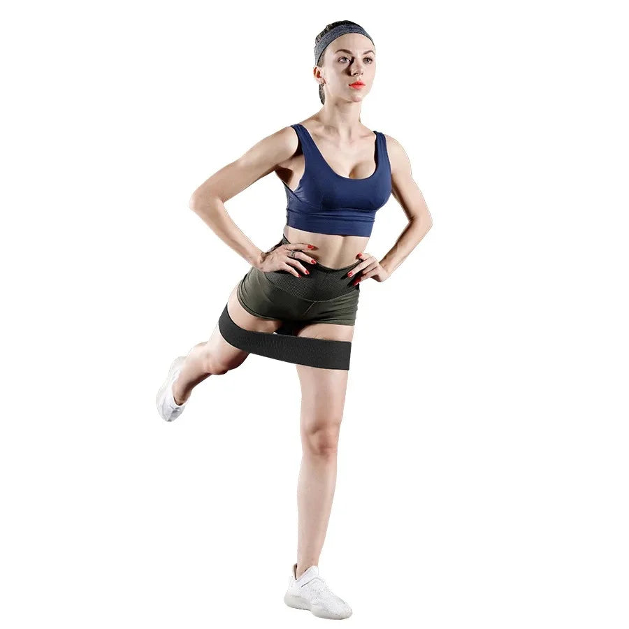 Woman wearing a blue sports bra and green shorts on a white background