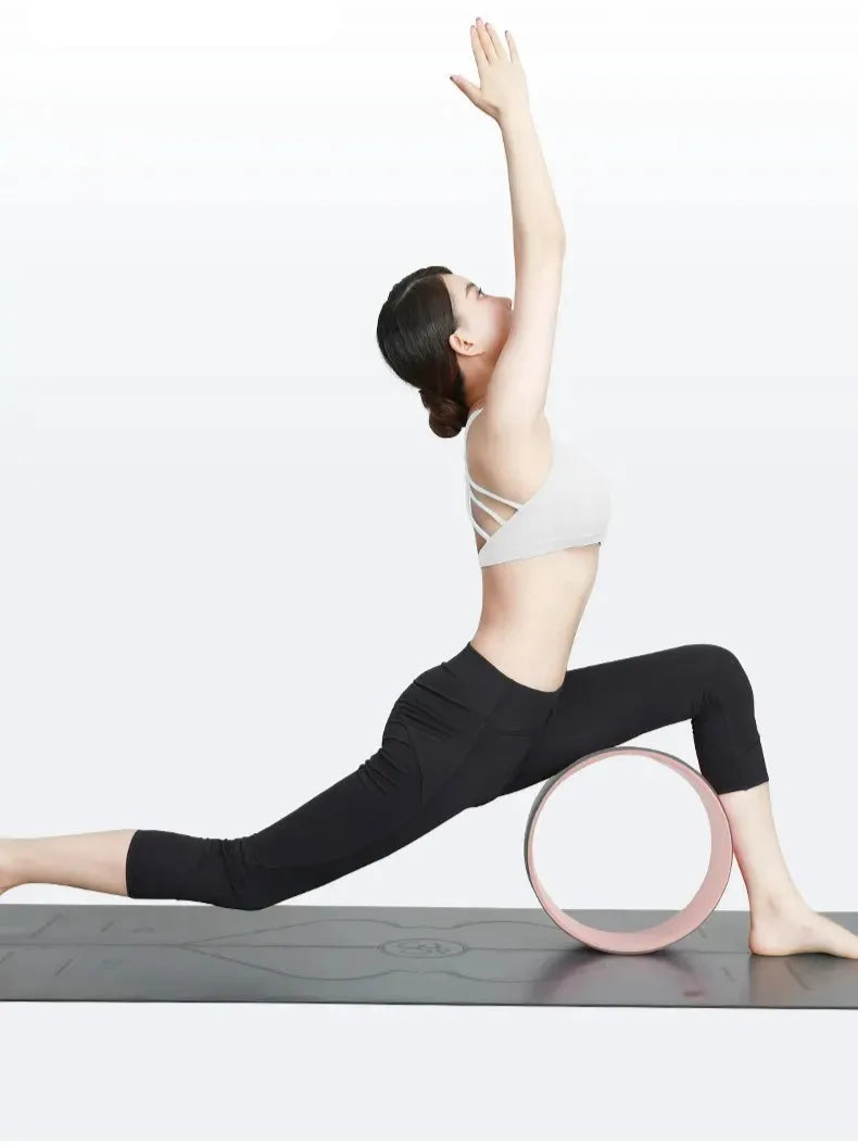 Woman in a yoga pose with a pink wheel on a white background