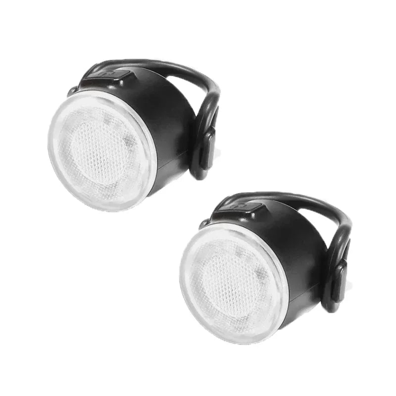 Two black and white bike lights on a white background