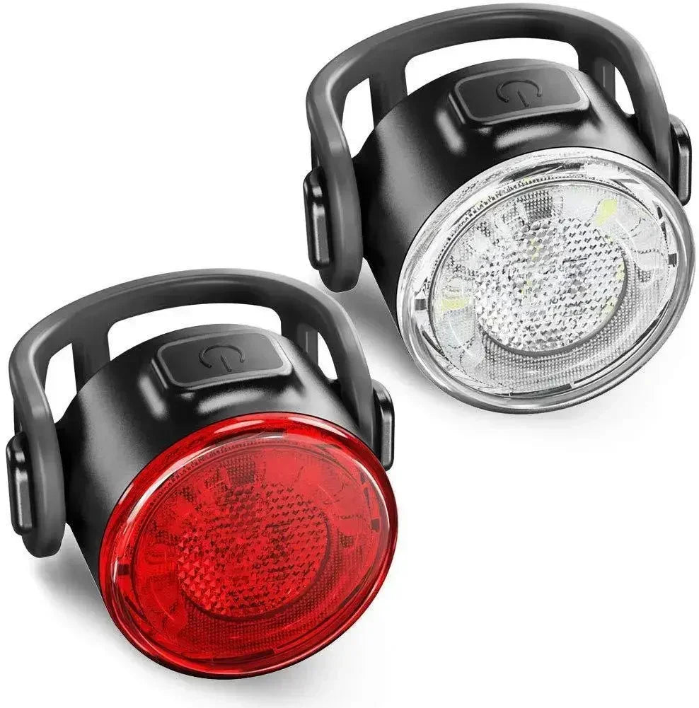 Two bicycle lights, one red and one clear with black casing, on a white background.