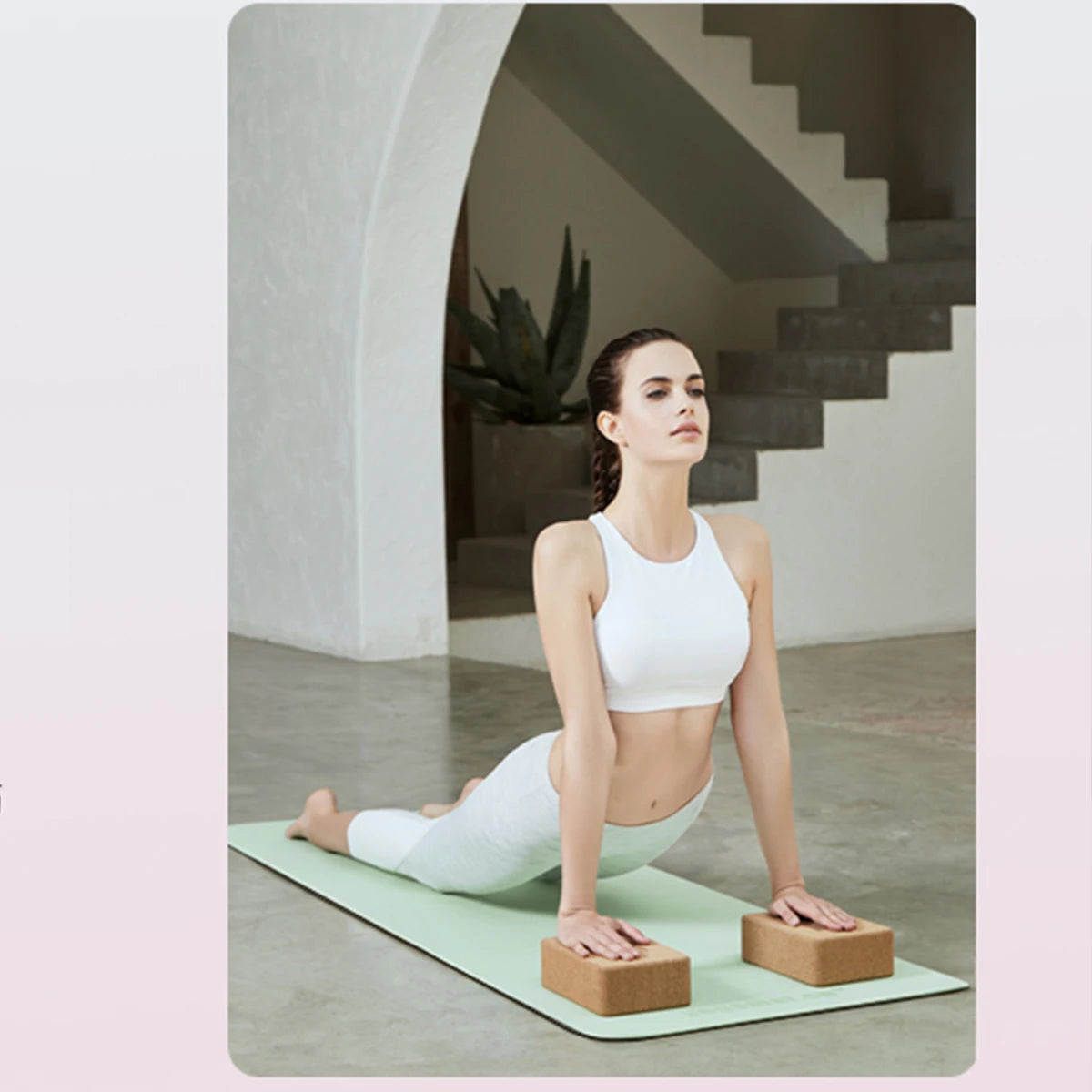 Woman practicing yoga on a mat with blocks in a modern indoor setting