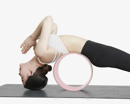 Person using a pink yoga wheel on a white background with text about pressure resistance.
