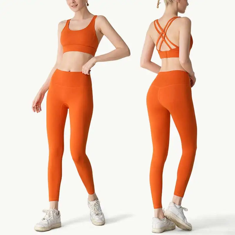 Orange sports bra and leggings set worn by a model on a white background