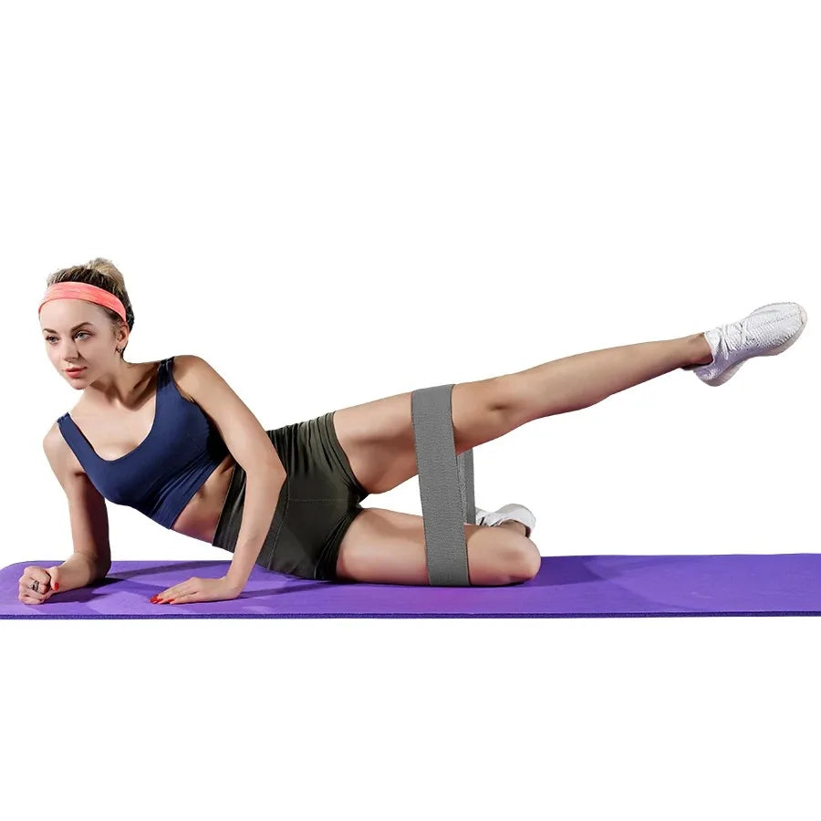 Woman exercising with a resistance band on a purple mat